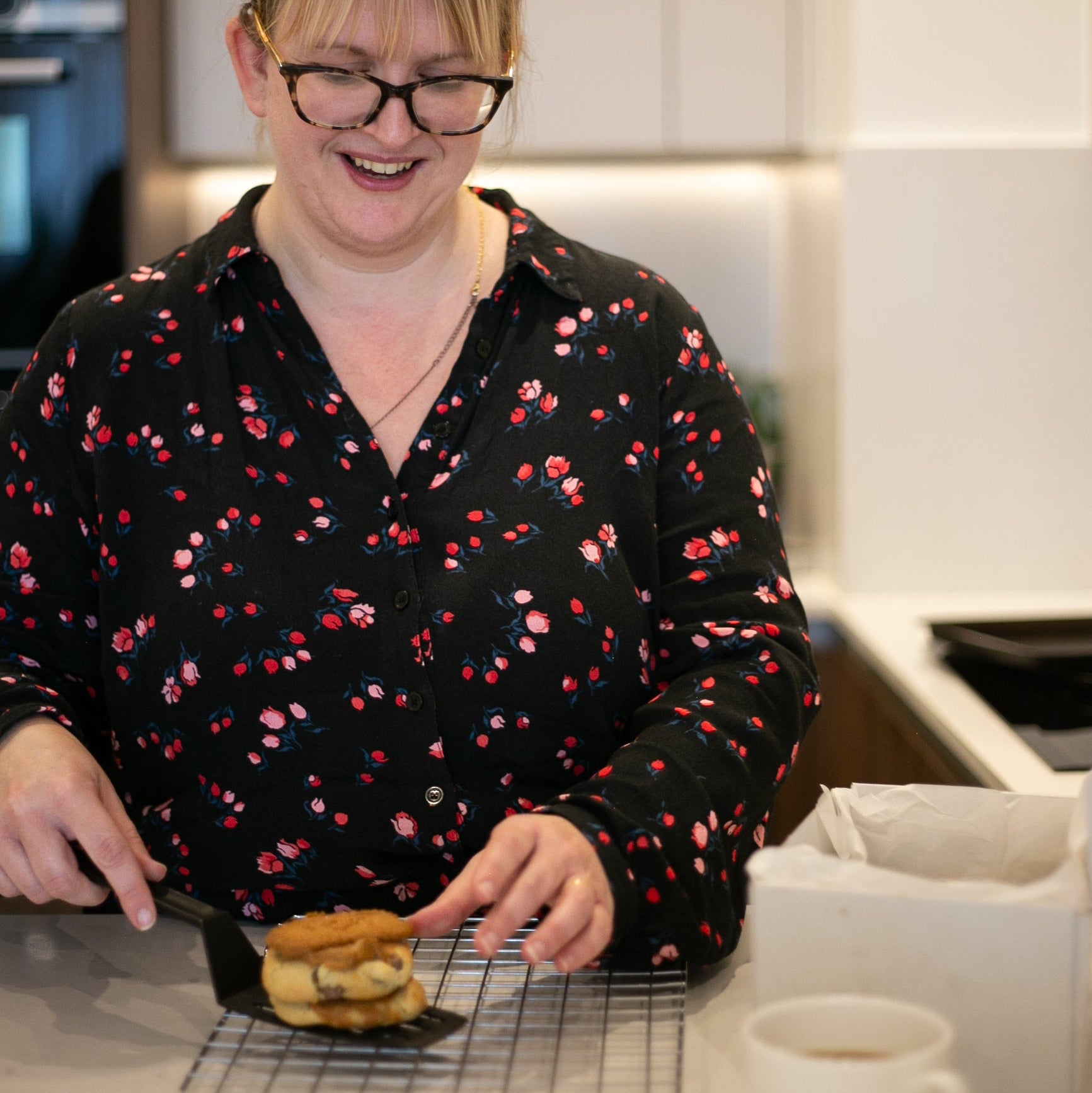 A woman moving a cookie on a spatula