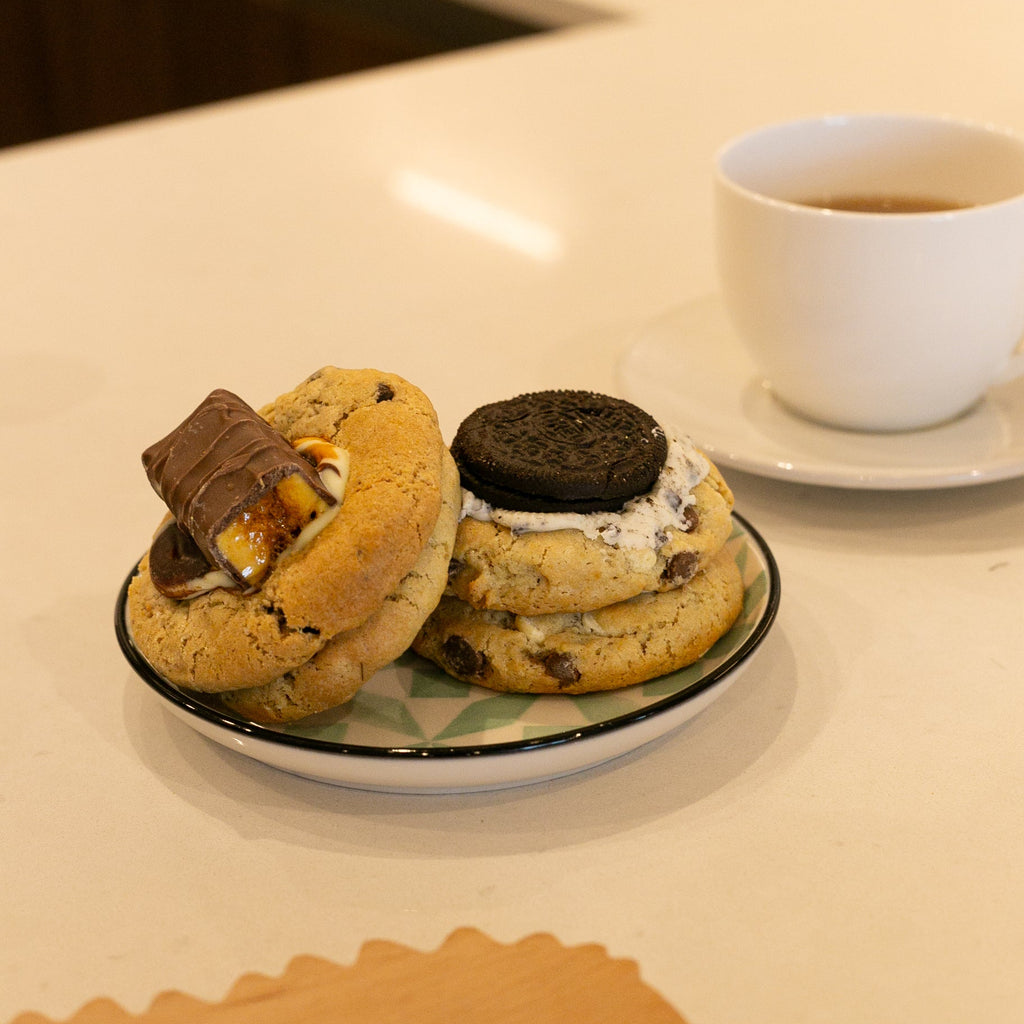 Plate with two cookies on next to a cup of tea
